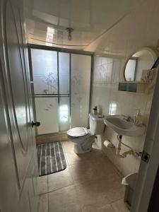 ein Bad mit einer Dusche, einem WC und einem Waschbecken in der Unterkunft casa nagüera in Nagua