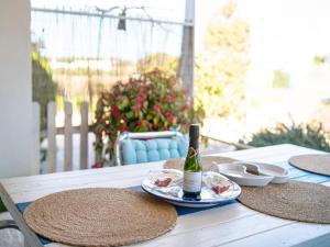 einen Tisch mit einer Flasche Wein und Hüten darauf in der Unterkunft Casa Rosella - Formentera Break in Sant Ferran de Ses Roques