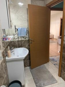 ein Badezimmer mit einem weißen Waschbecken und einer Holztür in der Unterkunft Premium apartment with furniture in Istanbul