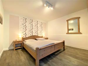 a bedroom with a bed and a mirror on the wall at Apartmenthaus am Nordseestrand Whg 5, An der Rennweide 1B, 78qm in Dangast