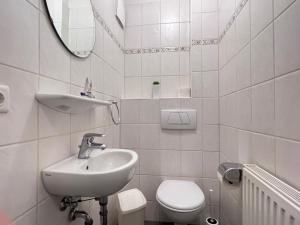 a white bathroom with a sink and a toilet at Apartmenthaus am Nordseestrand, Whg 3, An der Rennweide 1B, 75qm in Dangast +10 photos