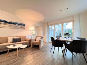a living room with a table and a couch at Apartmenthaus am Nordseestrand Whg 5, An der Rennweide 1B, 78qm in Dangast