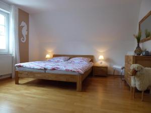 - une chambre avec un lit et une commode avec deux lampes dans l'établissement Haus Pier 24 An der Rennweide 24a 96qm, à Dangast