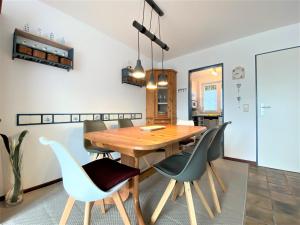 une salle à manger avec une table et des chaises en bois dans l'établissement Haus Mellum 75 qm, An der Rennweide 26c, à Dangast