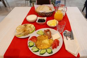 a table with a plate of breakfast food and orange juice at Hotel Boutique BUZI in Berat