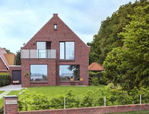 Cette grande maison en briques possède des fenêtres donnant sur une cour. dans l'établissement Haus Dangaster Gezeiten, An der Rennweide 32, 120qm, à Varel