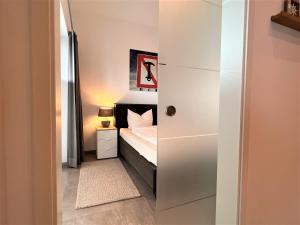 een kleine slaapkamer met een bed en een witte kast bij Loft Sonne & Mehr, Am Alten Deich 26 10 in Dangast