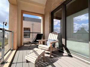 een veranda met een schommelstoel op een balkon bij Loft Sonne & Mehr, Am Alten Deich 26 10 in Dangast