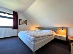 a bedroom with a white bed with a window at Haus Strandkieker, An der Rennweide 12c, 65qm in Dangast