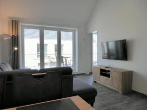 a living room with a couch and a flat screen tv at Penthouse "Möwenblick", Am Alten Deich 18 8 in Dangast