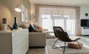 ダンガストにあるApartment Nordbudje, Am Alten Deich 14 8のソファと椅子のあるリビングルーム