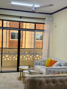 Cherry home في مومباسا: غرفة معيشة مع أريكة ونافذة كبيرة