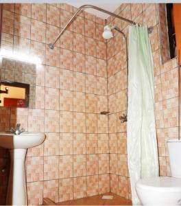 y baño con ducha, aseo y lavamanos. en Cherry home en Mombasa