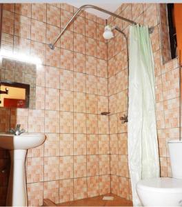 a bathroom with a shower with a toilet and a sink at Cherry home in Mombasa