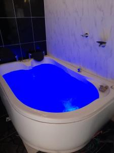 eine blaue Badewanne in einem Badezimmer mit Toilette in der Unterkunft Cabaña Alto de Luna para Pareja in La Vega