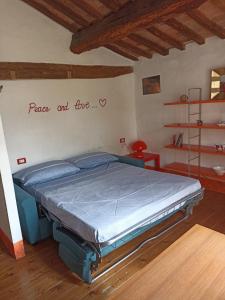 ein Schlafzimmer mit einem Bett mit den Worten Ruhe und Liebe an der Wand in der Unterkunft Corte delle Oche in Semproniano