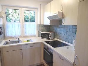 une petite cuisine avec un évier et un micro-ondes dans l'établissement Haus Seemöwe Hollwert 33d 90qm, à Dangast
