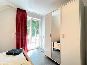 a bedroom with a bed and a large mirror at Apartmenthaus am Nordseestrand Whg 7, An der Rennweide 1B, 70qm in Dangast