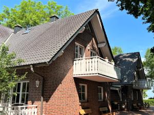 a brown brick house with a white balcony at Apartmenthaus am Nordseestrand Whg 7, An der Rennweide 1B, 70qm in Dangast