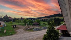 een uitzicht op een park met een zonsondergang in de lucht bij Zielona Przestrzeń in Polańczyk