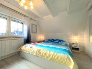 ein weißes Schlafzimmer mit einem Bett und einem Fenster in der Unterkunft Haus Waldesblick An der Rennweide 26a 75 qm in Dangast