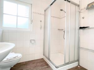 a bathroom with a shower and a toilet at Apartmenthaus am Nordseestrand Whg 10 An der Rennweide 1B, 70qm in Dangast +6 photos