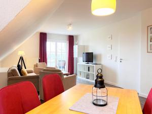 a living room with a table and red chairs at Apartmenthaus am Nordseestrand Whg 10 An der Rennweide 1B, 70qm in Dangast