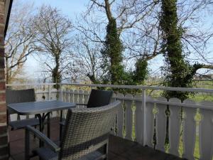 a balcony with a table and chairs on a fence at Apartmenthaus am Nordseestrand Whg 10 An der Rennweide 1B, 70qm in Dangast