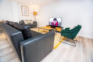 a living room with a couch and a television at Smart Central Birmingham 2 Bedroom Apartment in Birmingham