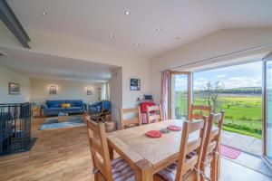 a dining room and living room with a table and chairs at 1 Peggies Barn - Rural cottage with great views in Maulds Meaburn