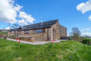a stone house with a grassy yard in front of it at 1 Peggies Barn - Rural cottage with great views in Maulds Meaburn
