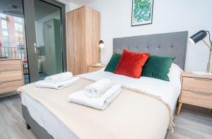 a bedroom with a large bed with towels on it at Smart Central Birmingham 2 Bedroom Apartment in Birmingham