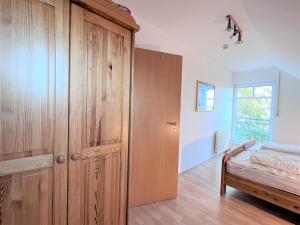 ダンガストにあるHaus Tante Clara Whg 26 Kukshörner Weg 8f 65qmのベッドルーム(大きな木製クローゼット、ベッド1台付)