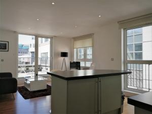 a living room with a island in the middle of a room with windows at Still Life Tower Hill Executive in London