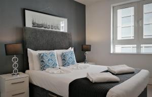 a bedroom with a large bed with two pillows on it at Still Life Tower Hill Executive in London