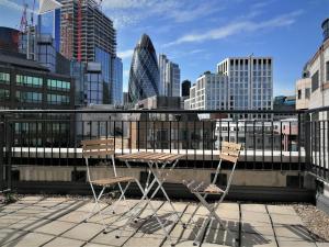 two chairs and a table on a balcony with a city skyline at Still Life Tower Hill Executive in London