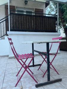 un tavolo da picnic rosa e una sedia rossa su un patio di Maison privée près de stade de France a La Courneuve