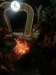a group of people sitting around a fire at night at Ecohotel Portillo in Vergara