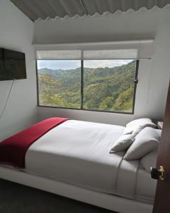 a bedroom with a large bed with a window at Ecohotel Portillo in Vergara