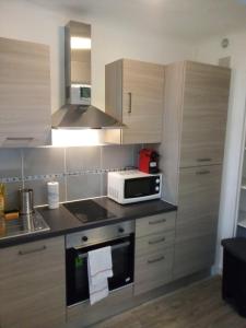 a kitchen with a microwave and a stove top oven at Bienvenus ! Appartement jaune in Marseille