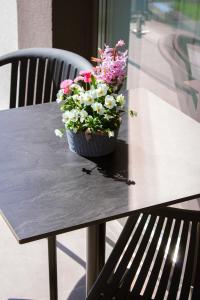 una olla de flores sentada en una mesa en TWIN prémium apartman, en Tihany