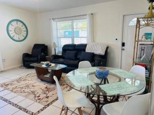 un soggiorno con tavolo e sedie in vetro di *Ocean Oasis: Beach Extras & Bikes & Surfboards* a Cocoa Beach