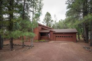a house with a garage in the woods at Drifting Snow Cabin - Pinetop, AZ in Indian Pine
