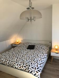 una camera da letto con un letto con un piumone bianco e nero di Repos du Cocher a Grez-Doiceau
