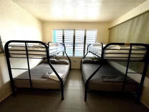 Ce dortoir comprend 2 lits superposés et une fenêtre. dans l'établissement Sandy Shores Retreat Beach Apt in Cabo Rojo, à Boqueron