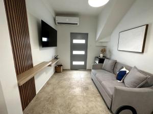 a living room with a couch and a tv at Urban-Styled Apartment in Santurce in San Juan