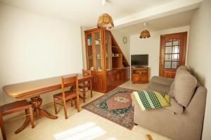 a living room with a couch and a table at Casa con jardín al lado de la playa in Viveiro
