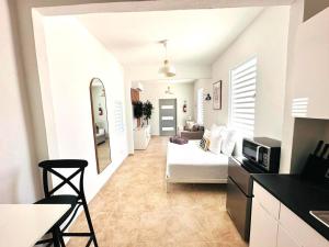 a white living room with a white couch and a kitchen at Centrally Located Modern Studio in San Juan