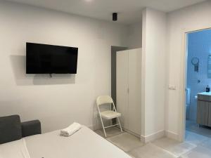Habitación con TV de pantalla plana en la pared en C10 Exclusiva zona Madrid cerca Bernabéu en Madrid