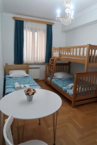 a small room with two bunk beds and a table at guest house Merci in Tbilisi City
